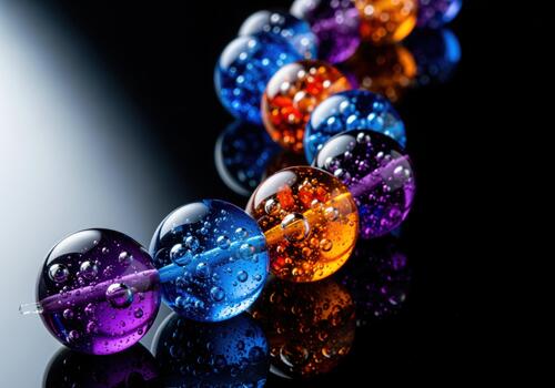 Serpentine arrangement of colorful glass beads with bubbles on a reflective black surface. photo
