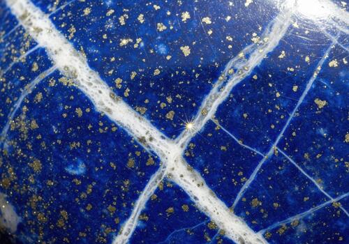Vibrant deep blue lapis lazuli stone texture closeup showing white calcite veins and sparkling pyrite photo