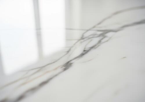 Luxurious close up of polished white marble surface with gray and gold veining and high gloss reflection. photo