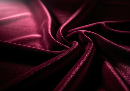 Rich burgundy velvet fabric texture close up showing elegant folds and luxurious drape photo