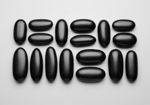 Smooth black river pebbles arranged in a grid pattern still life photo