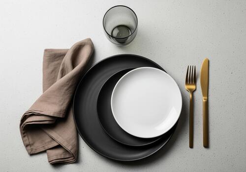 Elegant table setting with plates, flatware, glass, and linen napkin photo