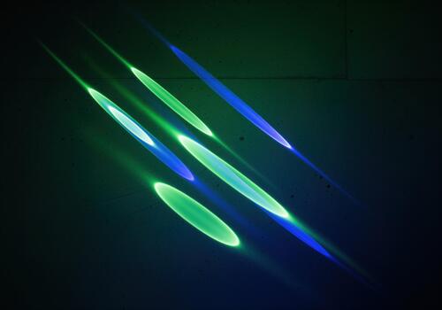 Dynamic diagonal streaks of glowing green and blue light refraction effect photo