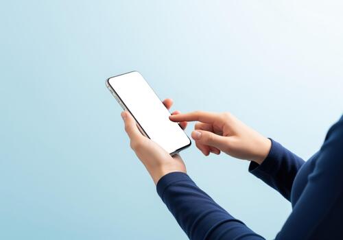 Female hands holding and tapping a modern smartphone with a blank screen on blue photo