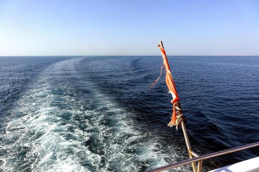 Waves Wake From a Yacht Sailing in the Red Sea at an Egyptian Resort With a Tattered Flag photo