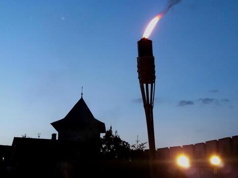 Nightfall Over Lutsk Castle With Illuminating Torchlight and Historic Tower photo
