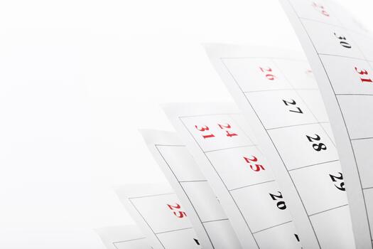 Calendar pages flipping in a playful motion showing multiple dates and numbers photo