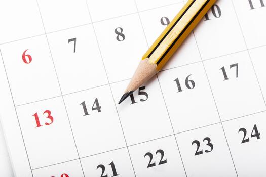 Important dates marked on a calendar with a yellow pencil for scheduling tasks photo