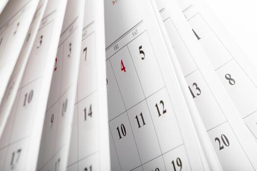 Calendar pages turning over with dates and days clearly visible in soft light photo