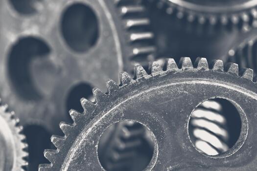 Close up of metal gears interlocking in a complex machinery setup in a workshop photo