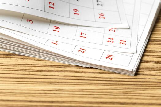Concept of time management with a calendar showing days and dates on wooden table photo