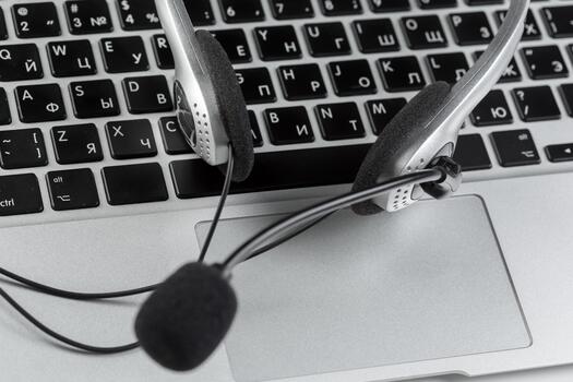 Headset placed on laptop keyboard showing remote working setup for communication tasks photo