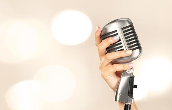 Classic microphone held in hand with soft bokeh background during a music event photo