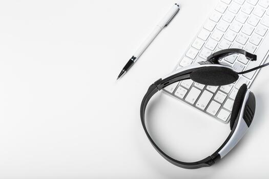 Headset and keyboard on a clean desk surface for remote work and communication tasks photo
