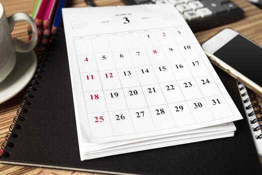 Planning and organizing tasks on a calendar at a desk in a modern office setting photo
