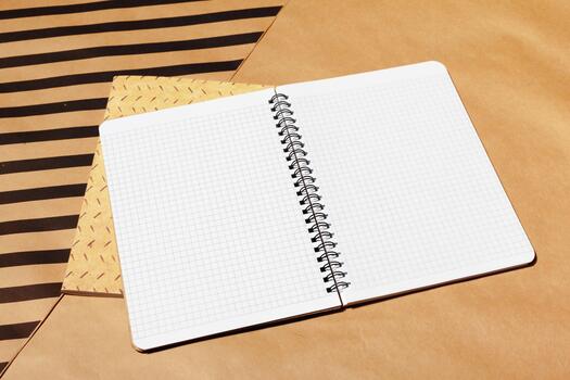 Open spiral notebook with graph paper on various brown paper backgrounds photo