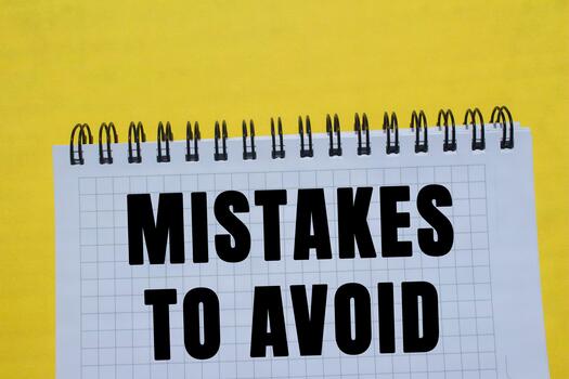 Mistakes to avoid message written on notebook page on yellow background. Conceptual mistakes to avoid symbol. Copy space. photo