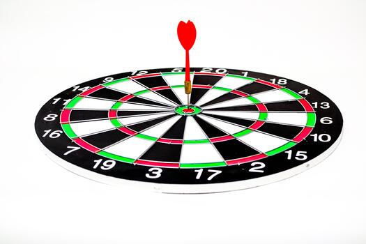Dart stuck in the bullseye of a dartboard, illustrating precision and accuracy, set on white photo