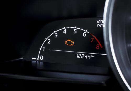 Check engine warning light on car dashboard, close-up of illuminated malfunction indicator symbol, vehicle diagnostics, car maintenance and engine problem alert concept photo