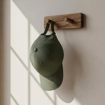 A visual prototype of a stylish green cap hanging on a wooden hook for advertising or product display photo