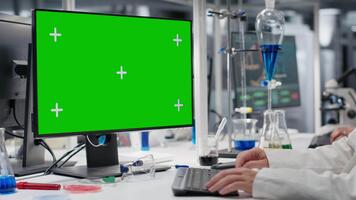 forskare skriver på tangentbord, använder sig av grön skärm dator program i laboratorium, körning behandling upptäckt. expert- använder sig av bioinformatik programvara på krom nyckel pc i steril labb, kamera b video