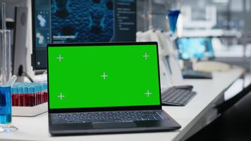 verde pantalla ordenador portátil y computadora monitor en laboratorio demostración molecular modelo software usado para investigación. Bosquejo cuaderno y ordenador personal en médico laboratorio mostrando adn datos, foque arriba Disparo video