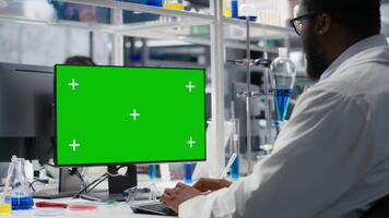 laboratoire ingénieur à bureau dactylographie sur isolé écran PC clavier, à la recherche à moléculaire modèle, Faire recherche Tâches. homme en utilisant génie biologique programme sur chrominance clé ordinateur dans médical laboratoire, caméra b video