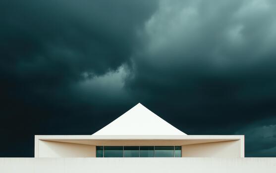 A white building with a triangular roof under a dark sky photo