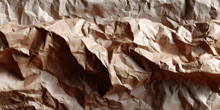 A close up view of crumpled brown paper creating an abstract textured background photo