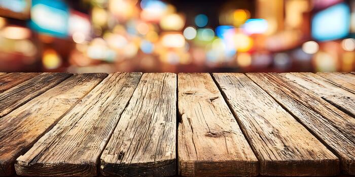 An old weathered rustic wooden table with vibrant bokeh lights blurring in the background creating an inviting and festive atmosphere photo