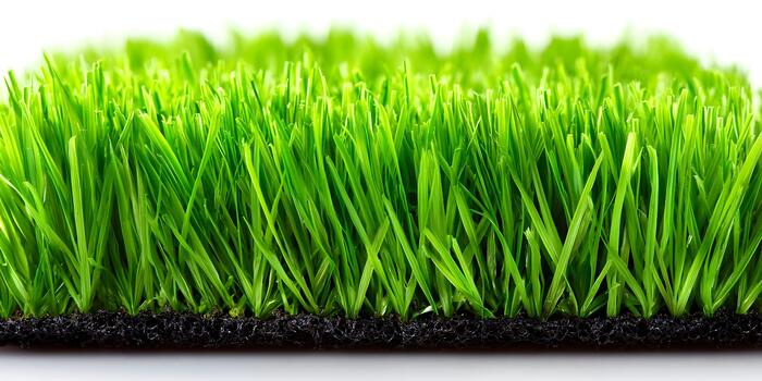 un cerca arriba ver muestra un ordenado parche de artificial verde césped con un oscuro texturizado base en un blanco antecedentes foto