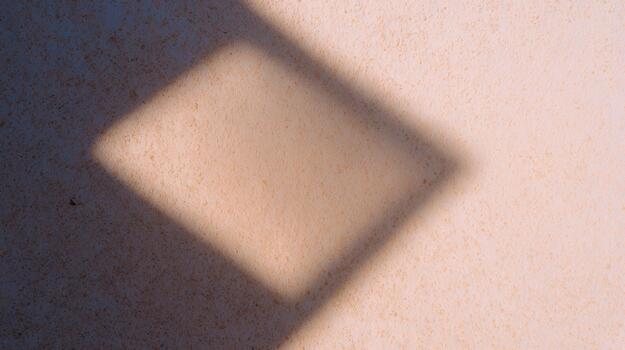 Shadow of a diamond shape on a textured wall photo