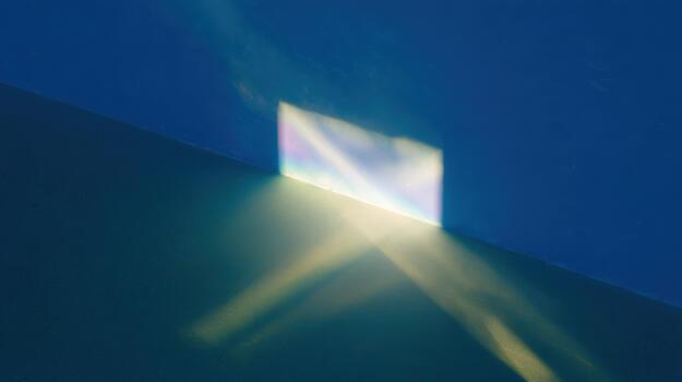 Light and shadow create reflections on a blue wall photo