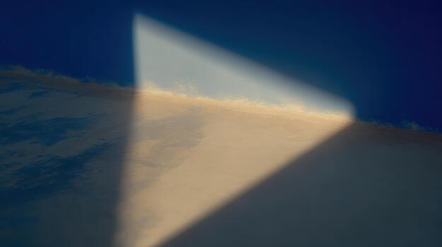 Light creating a triangular shadow on a wall photo