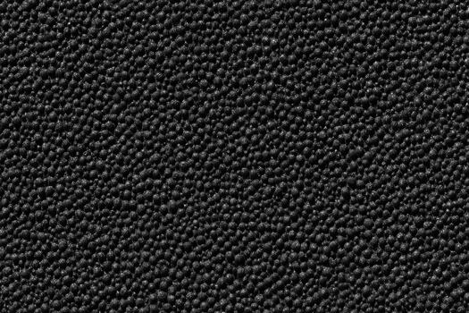 Dark textured surface with fine particles creating depth photo