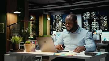 afrikansk amerikan strateg ripping en papper efter skrivning de fel aning, startar om arbete i rasa och skrynkling de sida ark. missnöje man gör en stavfel misstag medan transkribera. kamera a. video