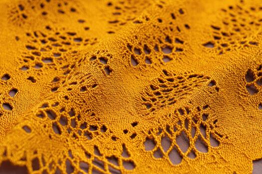 Lace fabric with intricate patterns in warm yellow color photo