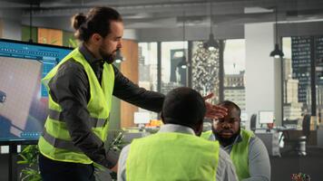 Professional development team consulting on real estate investment and construction strategy. Office features 3D models and documents illustrating modern property design concepts. Camera B. video