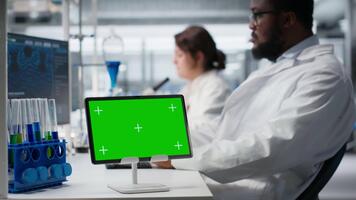 bioinformática científico trabajando en verde pantalla tableta en laboratorio, estudiando genómica información. mujer estudios adn hebra cartografía en croma llave dispositivo, contribuyendo a científico innovación, cámara si video
