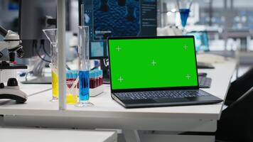 fechar acima do verde tela computador portátil e computador programa exibindo dna dados dentro laboratório. brincar dispositivo e bioinformática genômica Programas em pc dentro moderno laboratório, avançando científico conhecimento video
