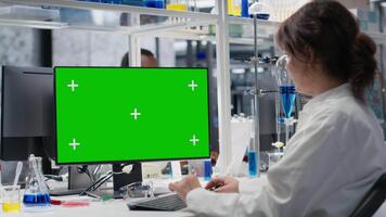 científico trabajando en verde pantalla ordenador personal en laboratorio, estudiando genómica información. biólogo estudios adn hebra cartografía en croma llave computadora, contribuyendo a científico innovación, cámara si video