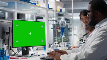 laboratorio trabajador utilizando aislado pantalla computadora para adn datos análisis, secundario clínico diagnósticos investigación. africano americano hombre estudiando genómica para humano salud estudiar utilizando Bosquejo ordenador personal, cámara si video