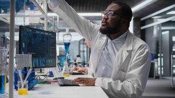 klinisk laboratorium teknolog Arbetar på granskning blod data på dator under diagnostik studie. forskning forskare fokuserar på validerar prov resultat använder sig av pc programvara, kamera en video