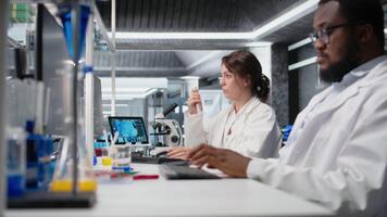 forskare uppgifter observationer från laboratorium experimentera för forskning dokumentation och godkännande av klinisk resultat. kvinna håller på med data skogsavverkning, tar anteckningar, bekräftande labb fynd, kamera en video