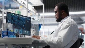 kvalitet kontrollera analytiker i laboratorium analyserar indikator lösning på arbetsstation använder sig av pc programvara. labb personal medlem testning kemisk vätska prov Begagnade för experiment med dator program, kamera b video