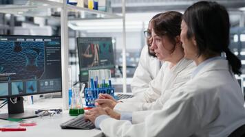 multirracial laboratorio técnicos a ordenador personal escritorio mirando a 3d molecular modelo. diverso nanotecnología investigadores utilizando bioingeniería programa en ordenador personal en médico laboratorio mostrando adn datos, cámara si video