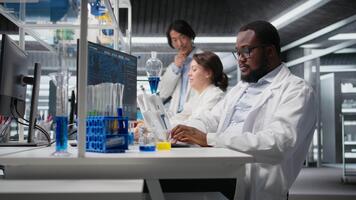 retrato de contento científico mecanografía en teclado, utilizando computadora programa para adn datos análisis en laboratorio conducción tratamiento descubrimiento. alegre investigador utilizando bioinformática software en laboratorio, cámara un video