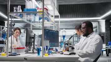 investigador utilizando computadora solicitud a revisión paciente datos en laboratorio. investigación instalaciones especialista utilizando bioinformática genómica software en ordenador personal en laboratorio, analizando resultados, cámara un video