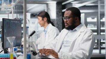 científico utilizando computadora programa para adn datos análisis en laboratorio, haciendo lluvia de ideas. laboratorio experto pensamiento, haciendo investigación utilizando bioinformática genómica software en ordenador personal, cámara si video