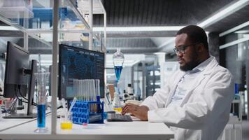 kemisk ingenjör i labb inspekterande kemisk föreningar i ampuller för renhet verifiering använder sig av pc programvara. man i laboratorium framställning reagens testa rör för analysera förfaranden på dator, kamera en video